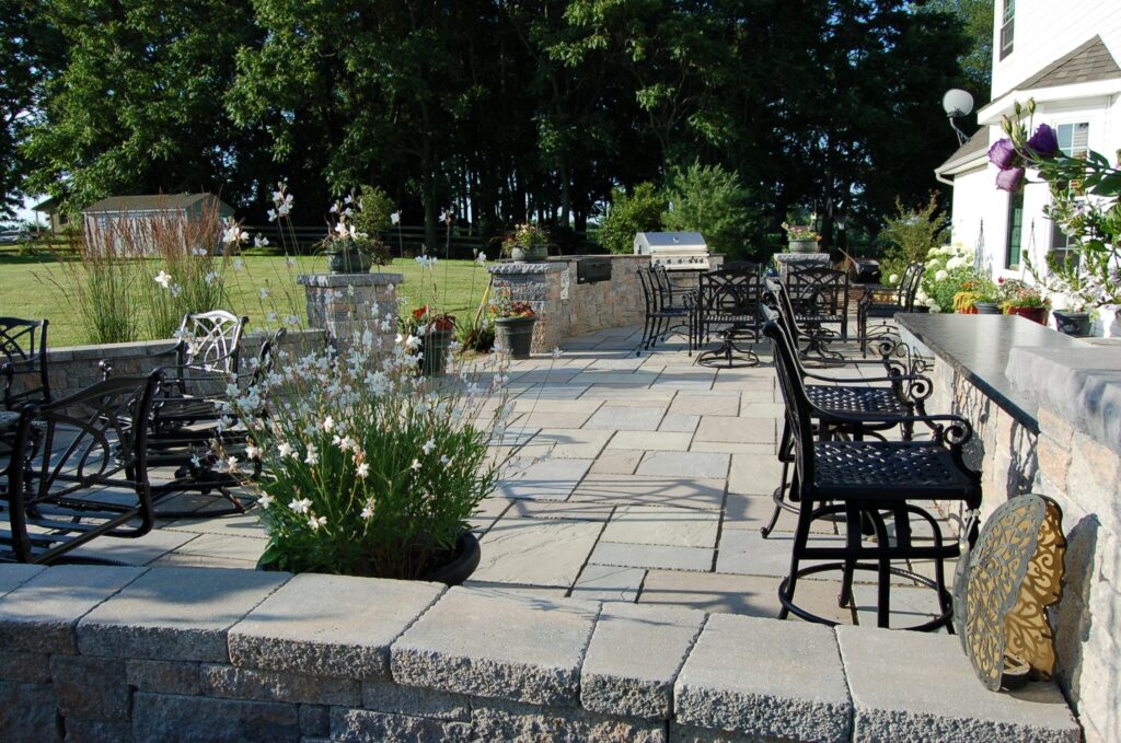 Patio with multiple seating areas and large yard from CKC landscaping