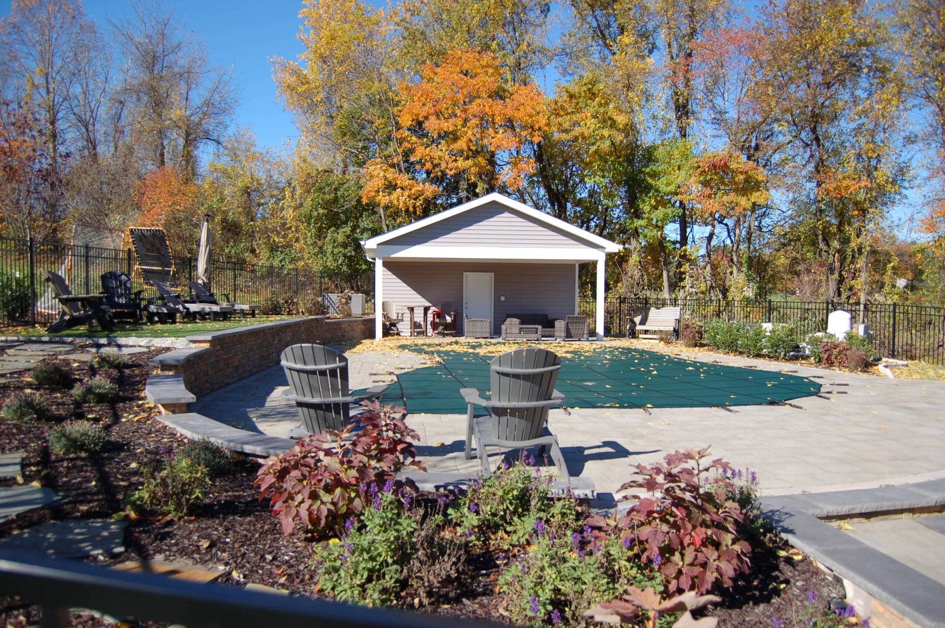 Autumn view of a CKC Landscaping-designed gazebo surrounded by mature trees and seasonal foliage in a tranquil garden setting.