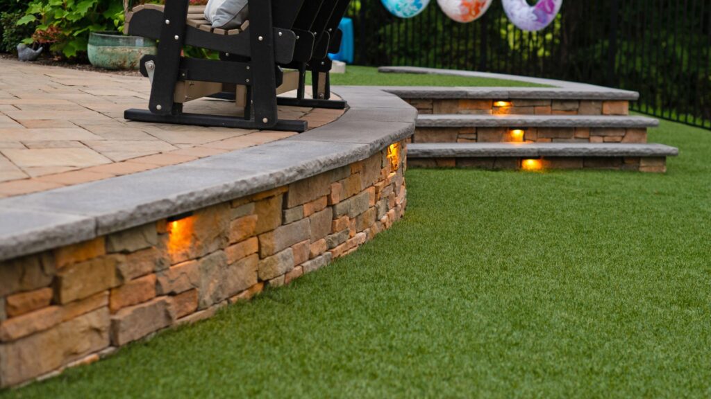 Outdoor lighting illuminates hardscaping in the early evening.